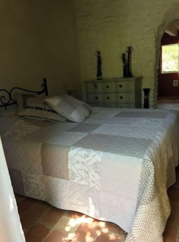 Un dormitorio con cama, cómoda y ventana.