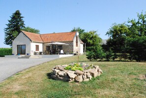 A two-story house with a stone facade and a tiled roof.