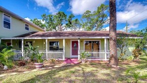 A single-story house with a front porch, a small garden, and a white picket fence. - Cozy 1BR Retreat w/ Porch – Near Beaches & Airport (Bradenton)