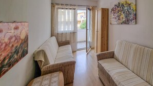 A living room with two sofas, a coffee table, and a painting on the wall. - Beach front apartment in Vir with WiFi (Vir)