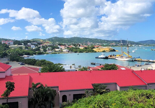 Un pueblo costero con un puerto, edificios de techo rojo y barcos.