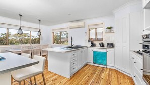 Una cocina moderna con armarios blancos, una isla central y un lavavajillas.