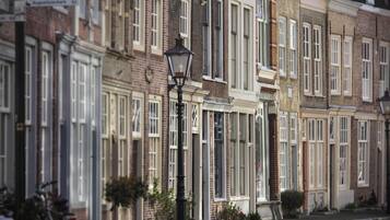 A row of traditional brick townhouses with uniform window designs and a central street lamp.
