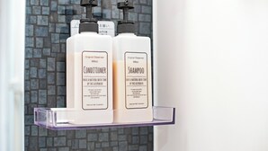 Two bottles of conditioner and shampoo on a clear shelf. - HOME Tengachaya3F (Osaka)