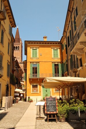 A narrow street with a building featuring a balcony and a signboard. - Casa Bella: Charming Apartment with a View of the Lake (Bardolino)