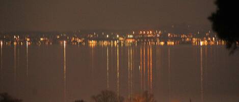 A nighttime view of a waterfront with buildings and trees.