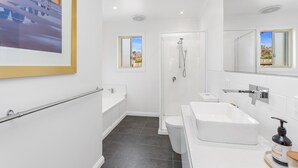 Un baño moderno con ducha, inodoro y lavamanos.
