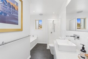 Un baño moderno con ducha, inodoro y lavamanos.