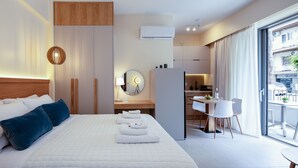 Una habitación de hotel moderna con una cama grande, un escritorio y una zona de comedor.