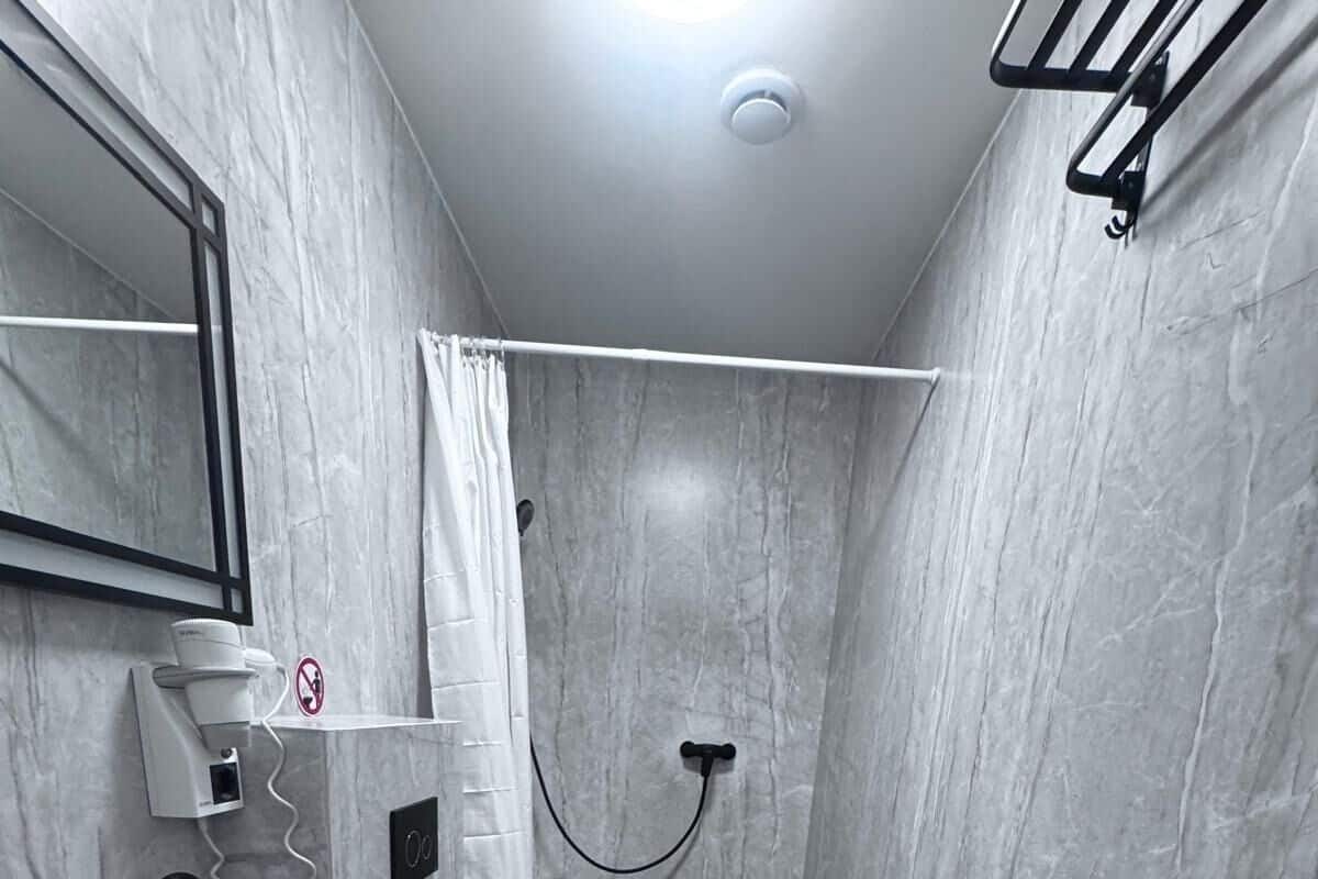 A modern bathroom with a black sink, toilet, and shower.