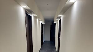 A long, narrow hallway with dark grey flooring and light-colored walls. - Capitol Zentrum - 24h - (Friedrichshafen)