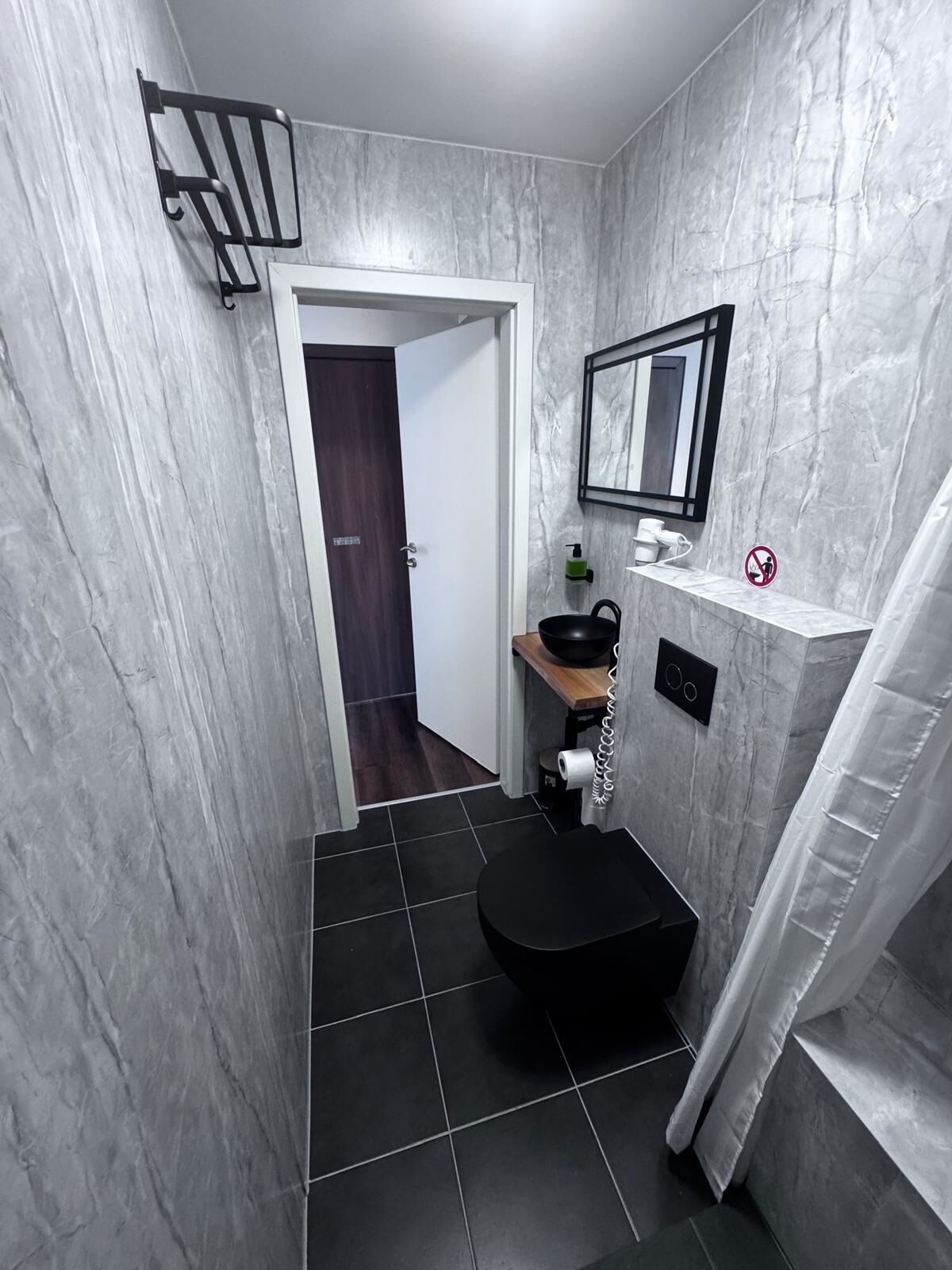 A compact bathroom with a toilet, sink, and shower area.