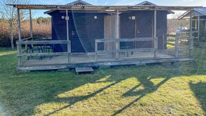 Eine rustikale Holzhütte mit Veranda und zwei weiteren Hütten.