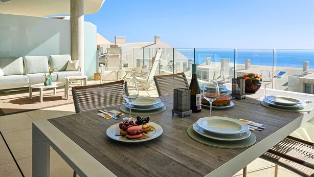 A dining area with a table set for two, overlooking a scenic ocean view. - Stunning sea views @ Stupa hills (Benalmádena)