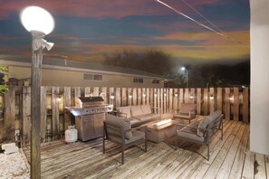 An outdoor patio with a grill, seating, and a light post.