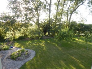 A well-maintained garden with a variety of trees and a neatly trimmed lawn. - Ferienwohnung in zentraler, ländlicher Lage (Groven)
