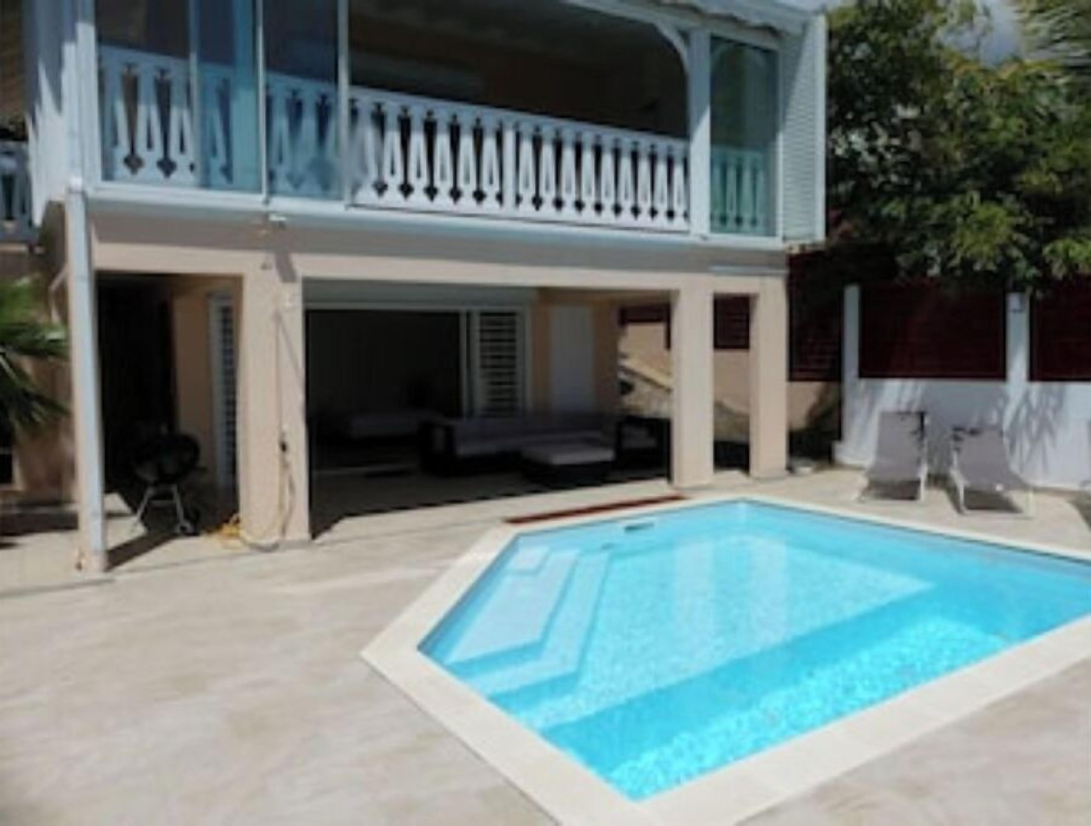 Ein zweigeschossiges Haus mit einem Schwimmbad.