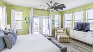 A bedroom with a bed, a TV, a ceiling fan, and a view of the outside. - New to Dune Allen Realty!!! (Santa Rosa Beach)