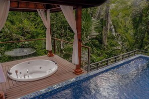 A wooden deck with a hot tub and a swimming pool, surrounded by lush greenery. - The Sebali Resort (Ubud)