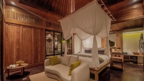 Un dormitorio con cama con dosel, paredes de madera, un sofá y una mesita de noche.