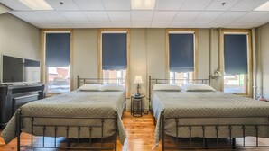 Une chambre d’hôtel avec deux lits, une télévision et une lampe.