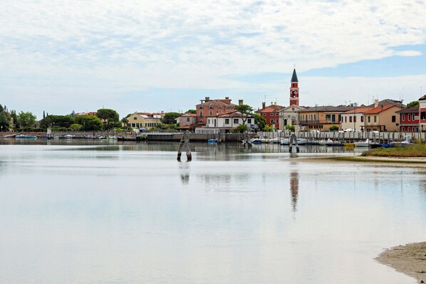 A waterfront view with buildings, a tower, and boats.