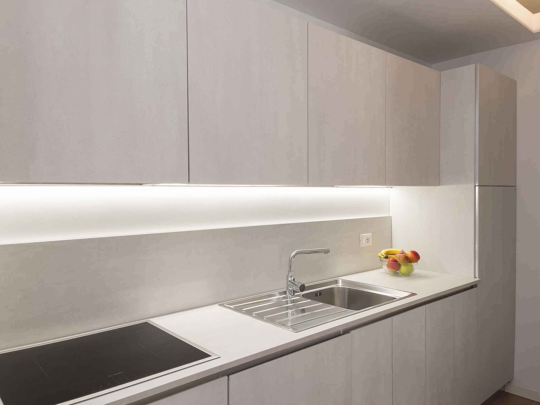 A modern kitchen with a built-in sink, a stovetop, and a countertop.