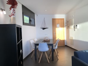 Un espace repas moderne comprenant une table, des chaises et une voile décorative.