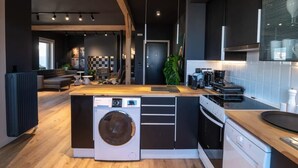 A modern kitchen with a central island, built-in appliances, and a cozy seating area. - City's Best-Kept Secret, Chic & Luxe Getaway (Kalamata)