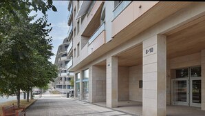 Een modern gebouw met een platte gevel, genummerd 8-10, met een overdekte entree en een zichtbare ingang op de begane grond.