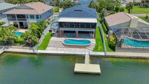 Ein Haus mit Pool, einer Anlegestelle und Blick aufs Wasser.