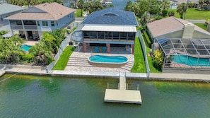 Una casa con piscina, muelle y vista al agua.