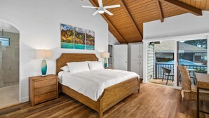 A bedroom with a wooden bed, a ceiling fan, and a view of the outside balcony. - Laule'a 'Ohana Hale - Luxurious 'Ohana home with A/C (Princeville)