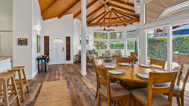 A spacious dining area with a wooden table set for four, surrounded by wooden chairs. - Laule'a 'Ohana Hale - Luxurious 'Ohana home with A/C (Princeville)