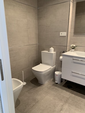 A modern bathroom with a toilet, bidet, and a small trash bin. - Apartment 817 on the waterfront with a view of the sea (Marbella)