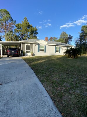 A single-story house with a garage, a driveway, and a well-maintained lawn. - Crowd favorite! Clean and peaceful stay! (Ocala)