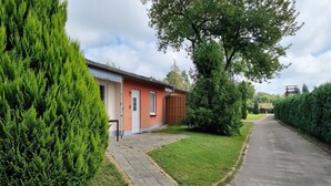A residential building with a paved driveway, a small porch, and a well-maintained lawn.