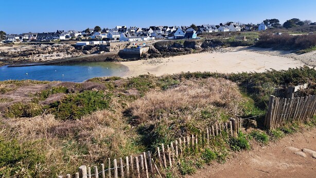 A coastal village with houses along the shoreline, a sandy beach, and a rocky outcrop. - Ploemeur 56, Kerroch 150m from the sandy beach (Ploemeur)