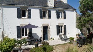 A white building with a balcony, outdoor seating, and potted plants. - Ploemeur 56, Kerroch 150m from the sandy beach (Ploemeur)