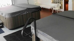 Habitación pequeña con dos camas, una mesita y una silla.