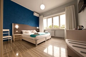 A modern bedroom with a bed, bedside tables, a chair, a radiator, and a window with curtains. - Star of Rome (Rome)
