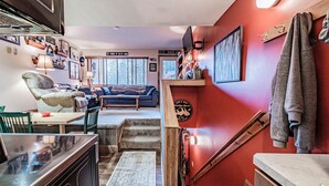 A cozy living room with a fireplace, a sofa, and a dining area with a table and chairs. - Maybe the best location on the mountain! Pool, hot tub, sleeps 6! (Newry)