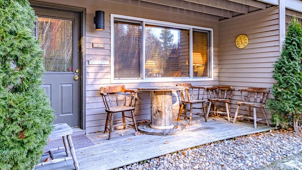 A wooden porch with a table and four chairs, a door, and a clock on the wall. - Maybe the best location on the mountain! Pool, hot tub, sleeps 6! (Newry)