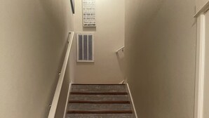 Una escala amb graons de fusta i una paret semblant a pedra.