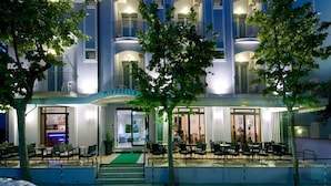 A multi-story hotel with a bar and outdoor seating area. - Hotel Mirabella (Cattolica)