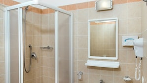 A bathroom with a glass-enclosed shower, a sink, a toilet, and a towel rack. - Hotel Mirabella (Cattolica)