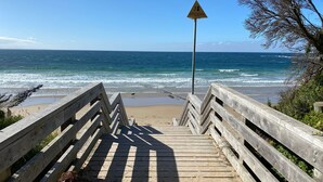 A wooden staircase leading to a beach with a lifeguard sign. - Beachfront at Cape Paterson (Cape Paterson)