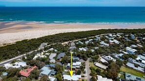 Overlooking the ocean, this beachfront area features a cluster of houses with a clear view of the sandy beach.