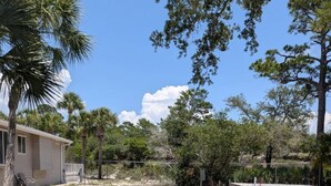 A residential area with a house, a fenced yard, and a tennis court. - Venture Out 484, Large RV Lot (Panama City)