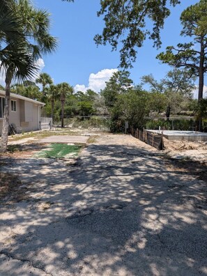 A residential area with a house, a fenced yard, and a tennis court.